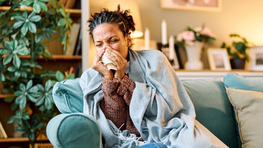 Woman on couch experiencing a cold