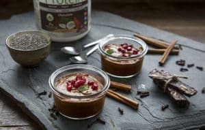 Side image of vegan and gluten free No-Cook Chocolate Chia Pudding surrounded by cinnamon sticks and Botanica Chocolate Perfect Protein
