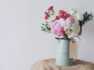 A picture of vase with white, red and pink colored rose flowers
