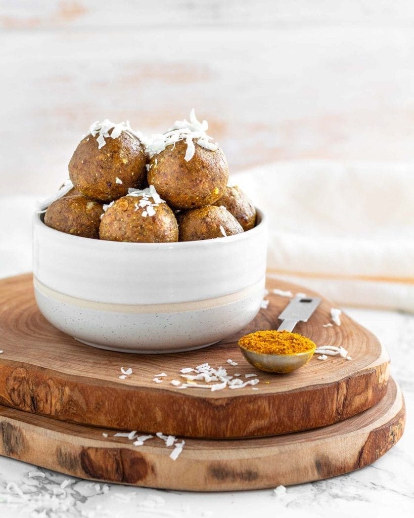 Turmeric Golden snack bites piled in a bowl garnished with shredded coconut