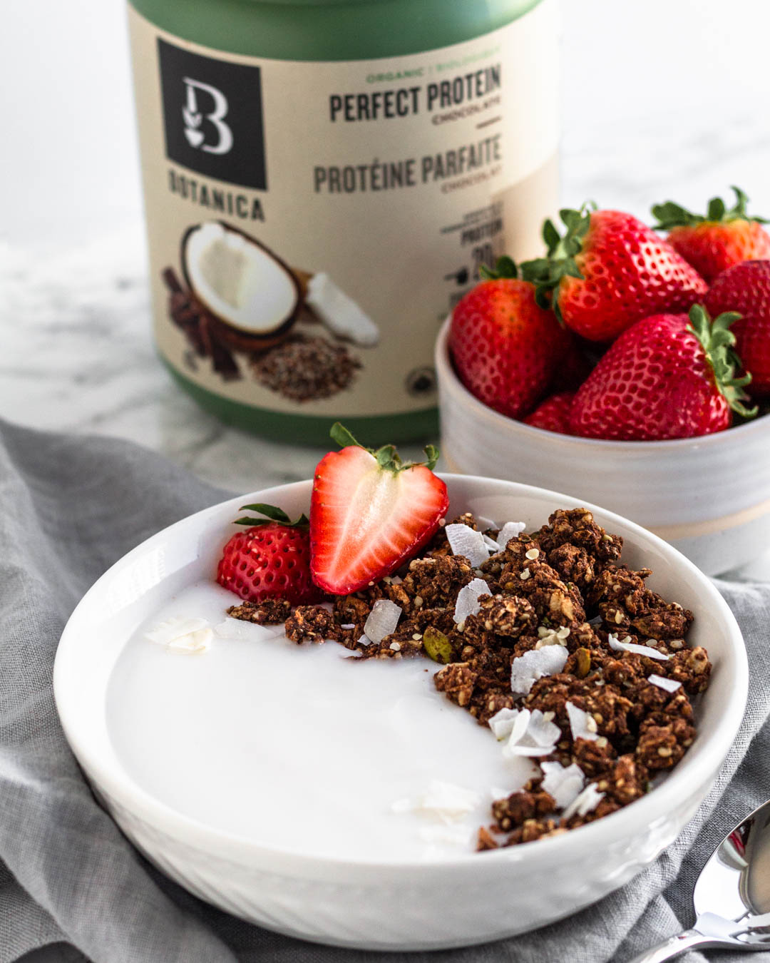 Protein packed chocolate granola recipe using Botanica health perfect protein chocolate protein powder. vegan and gluten free made with real food ingredients. Healthy breakfast. granola and yogurt.