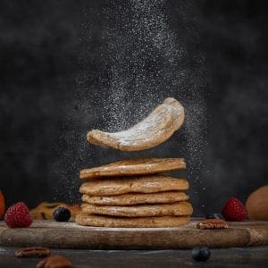 A side image of a stack of Vegan Protein-Packed Vanilla Pancakes made with flour, maple syrup, baking powder and Botanica Health Perfect Protein Vanilla.