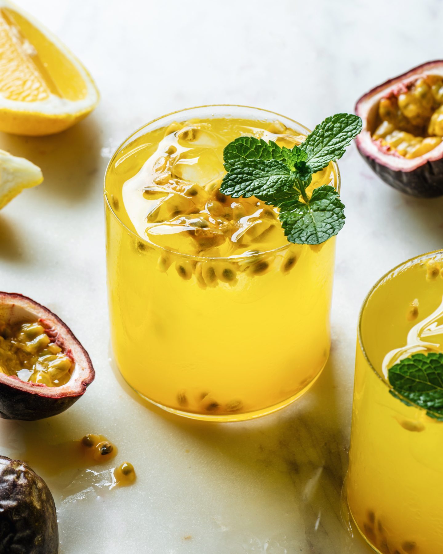 Refreshing Passionfruit Mint Lemonade in a glass next to sliced passionfruit