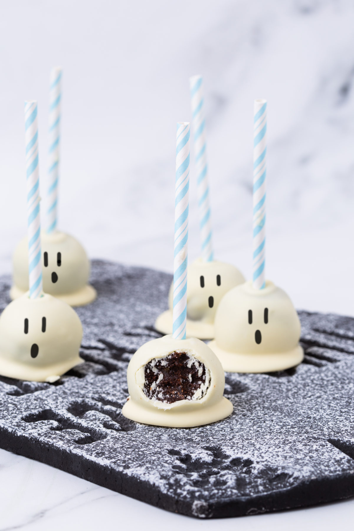 Lay view of healthy ghost cake pops with a bite taken out