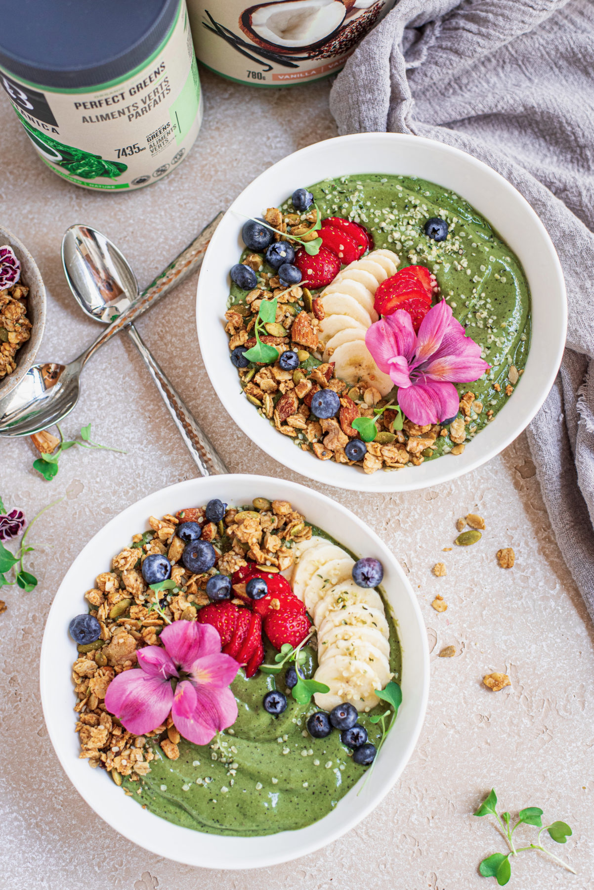 flat-lay of 2 vegan green smoothie bowls and Botanica Perfect greens and Perfect Protein Chocolate